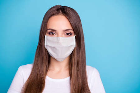 Close-up portrait of her she nice-looking lovely winsome pretty cheerful straight-haired girl stay home quarantine wear breathing mask isolated over bright vivid shine blue backgroundの写真素材