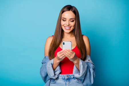 Portrait of positive cheerful girl student use smartphone read repost share social media news wear...
