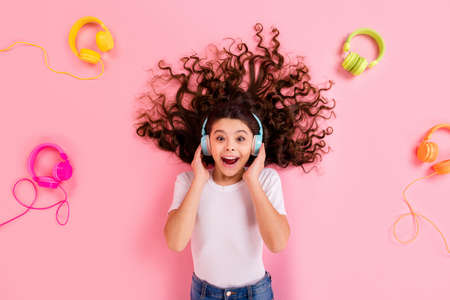 Top view above high angle flat lay flatlay lie concept portrait of nice beautiful cheerful cheery wavy-haired girl listening different style soul jazz funk isolated over pink pastel color backgroundの写真素材