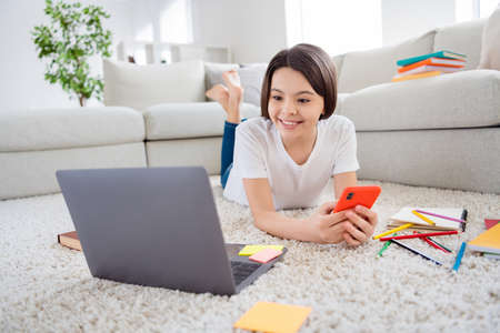 Photo of little pupil hispanic school lady using telephone classmates look notebook screen online...