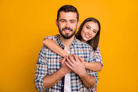 Portrait of tender gentle man woman spouses couple hug embrace cuddle piggyback enjoy rest relax valentine day date together wear plaid clothes isolated over bright shine color backgroundの写真素材