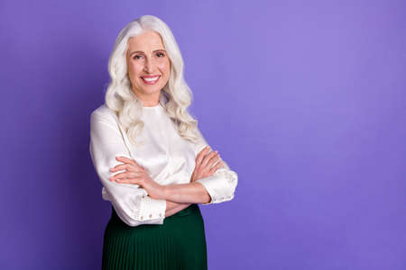 Turned photo of satisfied old woman successful freelancer cross hands enjoy working in her company decide solution wear good look outfit isolated over vivid color backgroundの写真素材