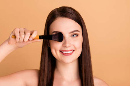 Close up photo of positive cheerful girl cover her eyes hold brush use apply rouges want be beauty queen in prom event party isolated over pastel color backgroundの写真素材