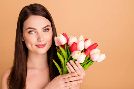 Close up photo of positive cheerful girl enjoy present for 8-march hold flowers given after colage beauty spa salon isolated over pastel color backgroundの写真素材