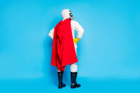 Full body back rear spine view photo confident man doc put hands waist look copyspace ready stop novel covid epidemic spread wear goggles yellow latex gloves isolated blue color backgroundの写真素材