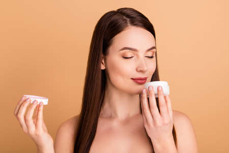 Excellent aroma I will buy it. Close up photo of charming woman hold jar cream smell enjoy want purchase new glamour treatment to make her skin pure silky isolated over pastel color backgroundの写真素材