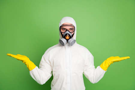 Portrait of his he nice professional disinfectant workman wearing gas mask holding on two palms copy space quarantine restrictions choose choice decide isolated over green pastel color backgroundの写真素材