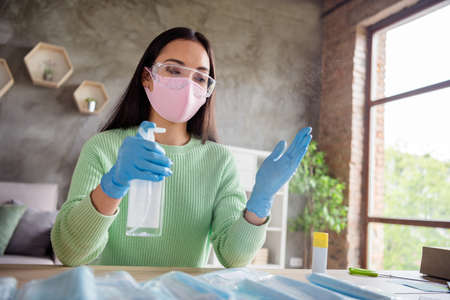 Photo of  lady hands latex gloves business organize order face medical masks handmade package spraying sanitizer arms safety concept online delivery shop commerce home office indoorsの写真素材