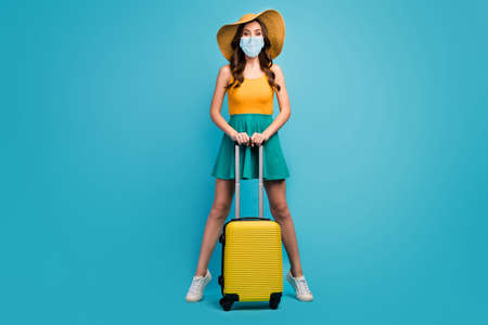 Full length body size view of her she pretty lady traveler hold rolling case railway bus station check-in open destination border wear mask isolated bright vivid shine vibrant blue color backgroundの写真素材
