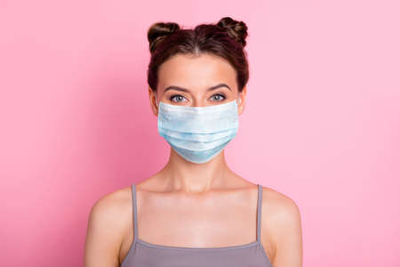 Close-up portrait of her she nice-looking attractive charming lovely pretty girl wearing medical reusable mask preventive measures stop illness isolated over pink pastel color backgroundの写真素材
