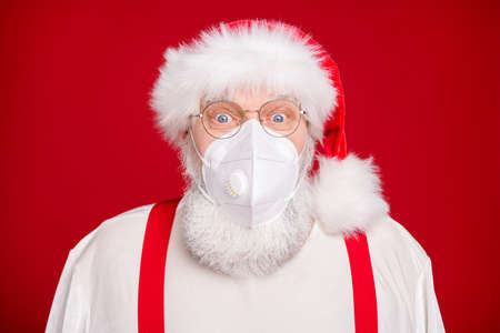 Hello kids. Closeup photo old bearded happy santa talk children video call remote internet online facial webcam view work wear respirator mask headwear shirt suspenders isolated red backgroundの写真素材