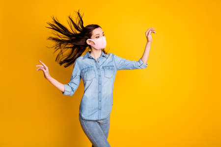 Profile side photo of charming elegant girl look copyspace raise hands haircut wind blow air wear casual style clothes medical mask isolated bright color backgroundの写真素材