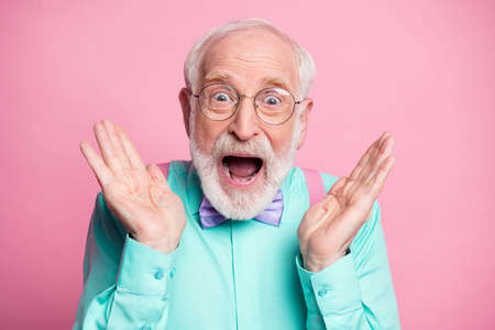 Closeup photo of funky crazy grandpa hands raised up see discount low shopping prices wear specs mint shirt suspenders bow tie isolated bright pink pastel color backgroundの写真素材