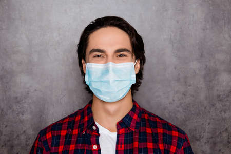 Close-up portrait of his he attractive cheery brunette healthy guy wearing reusable respirator gauze mask co2 cov air pollution isolated over dark gray industrial wall color backgroundの写真素材