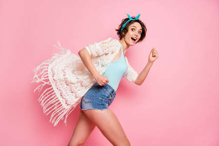 Profile photo of beautiful attractive lady good mood rushing student party wear headband lace cloak singlet mini denim shorts isolated pastel pink color backgroundの写真素材