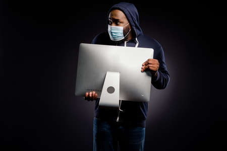 Photo of nervous afro american guy hold pc screen rob digital technology store look copyspace police...