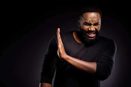 Photo of frustrated afro american guy hold hand copyspace avoid looting close eyes wear sweater...