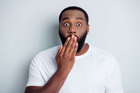 Photo of helpless troubled dark skin african american guy unfairly society hate black citizens hold arm on mouth not believe last breaking news in danger isolated grey color backgroundの写真素材