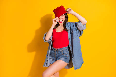 Portrait of positive cheerful crazy funny youth teenager girl touch her street style headwear enjoy rejoice scream wear modern tank-top isolated over bright color backgroundの写真素材
