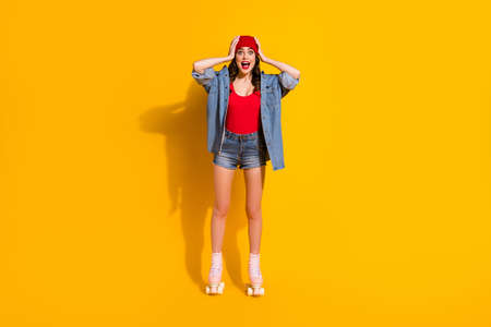New roller skates sales omg. Full length photo excited surprised youngster fit girl rider impressed touch hands red headwear wear tank-top jeans isolated bright color backgroundの写真素材