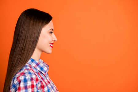 Close-up profile side view portrait of her she nice attractive lovely lovable winsome cheerful straight-haired girl wearing checked shirt isolated on bright vivid shine vibrant orange color backgroundの写真素材