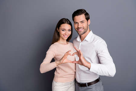 Forever love. Photo attractive lady handsome guy couple stand close hugging making heart figure hands fingers celebrating anniversary wear shirt pullover isolated grey color backgroundの写真素材