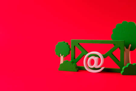 Close-up view of green mailbox form figure trees oaks save ecology planet refuse paper bill recycle isolated over bright vivid shine vibrant red color backgroundの写真素材