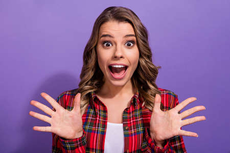 Close-up portrait of her she nice attractive amazed crazy cheerful cheery girl in checked shirt great cool news isolated over bright vivid shine vibrant lilac violet purple color backgroundの写真素材