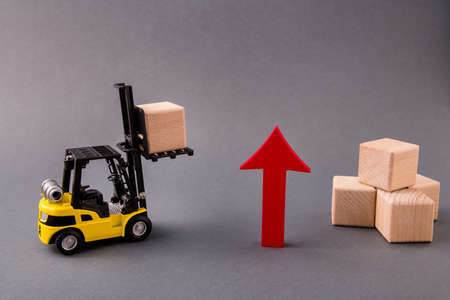 Photo of loader delivering bringing wooden cube supply management, arrow pointing up commerce rise raising sales import export program isolated over dark pastel grey color backgroundの写真素材