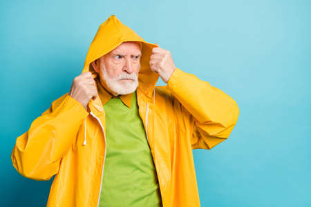 Portrait of his he nice serious displeased dissatisfied grey-haired man wearing yellow topcoat bad...