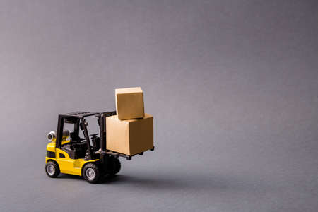 Photo of small electric truck carrying bringing delivering stuff in boxes, fast shipment transportation isolated over dark pastel grey purple violet color backgroundの写真素材