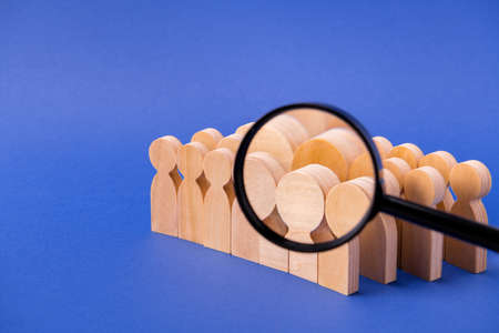 Loupe lens enlarging searching looking for new candidate wooden figures leaders hiring specialist expert head hunter isolated over bright vivid shine vibrant blue color backgroundの写真素材