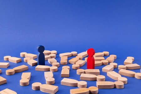 Two wooden figures leaders winners entrepreneurs businessmen standing among faceless members lying isolated over bright vivid shine vibrant blue color backgroundの写真素材