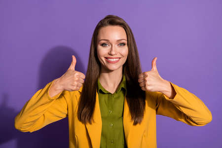 Photo of confident beautiful lady successful person raise thumb fingers up express agreement wear yellow office blazer suit green blouse shirt isolated purple pastel color backgroundの写真素材