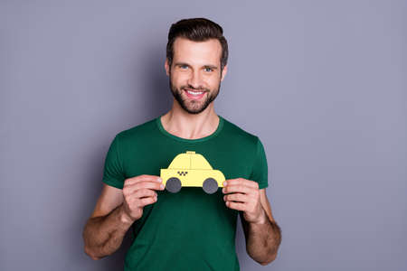 Portrait of cheerful confident guy hold hand paper card car enjoy taxi service on spring time tourism weekend rest relax wear trendy clothes isolated over gray color backgroundの写真素材
