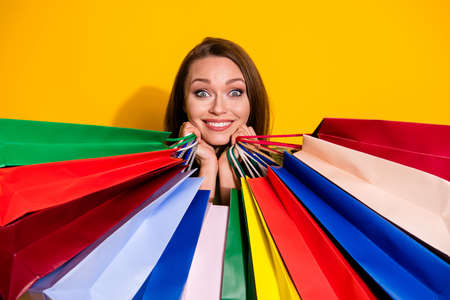 Photo of charming funny pretty lady good mood hold many shopping bags cool sales addicted shopaholic wear green sweatshirt isolated vivid bright yellow color backgroundの写真素材