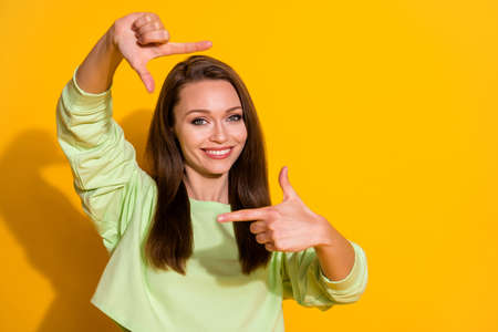 Portrait of positive cheerful girl make sign fingers imagine she make picture photo travel trip wear good look pullover isolated over shine color backgroundの写真素材