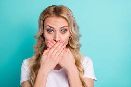 Portrait of astonished girl make mistake share friends secret close cover hands lips wear good look outfit isolated over green turquoise color backgroundの写真素材