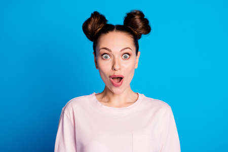 Closeup photo of attractive pretty shocked lady two funny buns cheerful mood listen amazing good news wear casual white pink t-shirt isolated bright blue color backgroundの写真素材