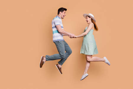 Full length profile photo of attractive lady and handsome guy funny married couple jumping high up...