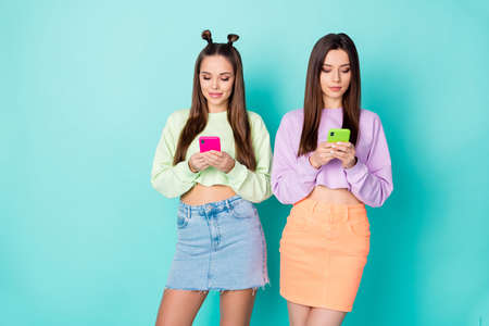 Photo of two cool funny sisters ladies best friends looking telephone hands chatting each other wear...