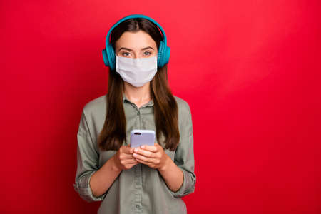 Portrait of healthy girl wearing safety mask listening hit radio playlist isolated bright vivid...