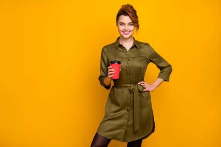 Portrait of her she nice-looking attractive lovely pretty charming cheerful cheery wavy-haired girl drinking hot sweet cacao isolated on bright vivid shine vibrant yellow color backgroundの写真素材