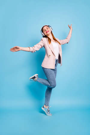 Full size photo of candid content girl have free time listen music stereo melody headset enjoy sound imagine she dance party wear trendy outfit isolated over blue color backgroundの写真素材