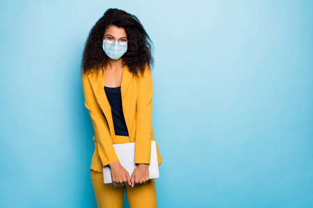 Photo of attractive chic classy lady agent broker real estate carrying laptop wearing safety gauze mask mers cov infection prevention stop pandemia isolated blue color backgroundの写真素材