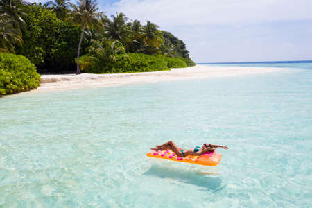 Nice fit slim thin attractive girl freelance living on island floating lying on rubber mattress ocean water enjoy joy calm wild summertime, tourism voyage immigration migration move relocationの写真素材