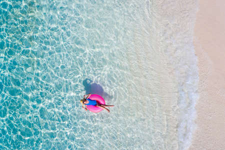 Top above high angle aerial drone view of her she attractive girl floating on rubber ring in transparent ocean water coastline sunny, weather spending season luxury place summertime daydreamの写真素材