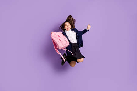 long-haired girl jumping having fun free spare time isolated lilac violet purple pastel color backgroundの写真素材