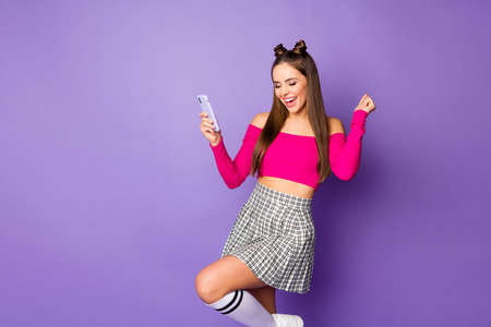 Photo of pretty youngster crazy lady two funny buns hold telephone celebrate money income wear pink...