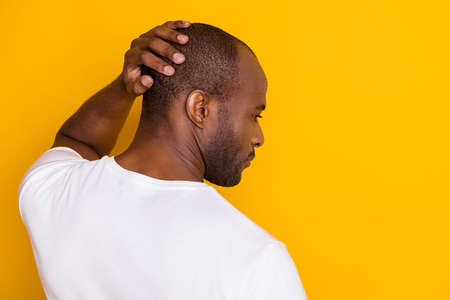 Close-up rear back behind view portrait of his he nice attractive serious guy touching hairdo care skincare neat grooming service isolated over bright vivid shine vibrant yellow color backgroundの写真素材